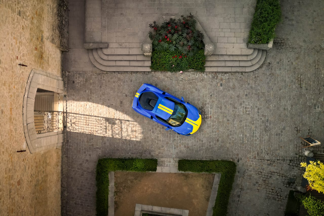 Vue aérienne d'une Ferrari 296 GTB dans une cour de château