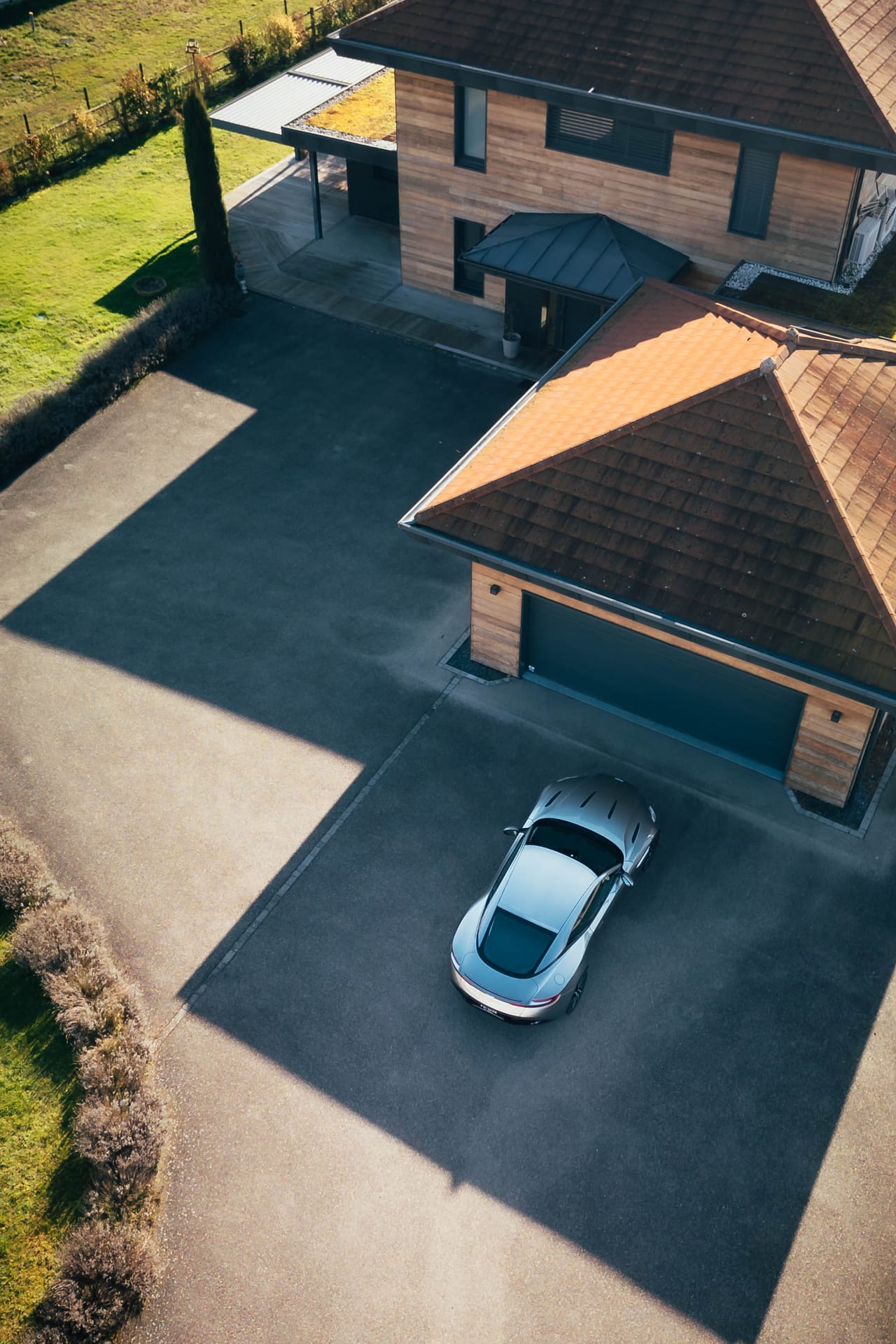 Aston Martin DB11 livrée devant une villa, vue drone